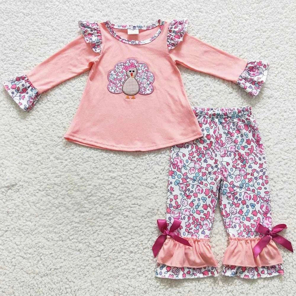 Baby girls fall outfit with turkey print top and floral pants with ruffle and bow details in pink and white colors