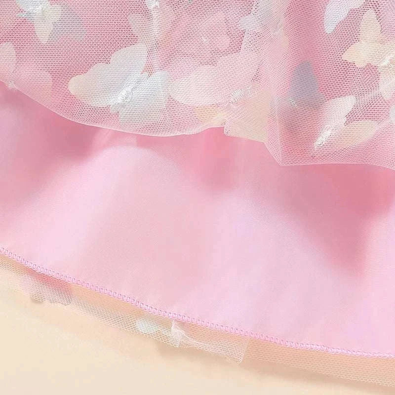Close-up of pink baby girls tutu fluffy skirt with butterfly print and tulle layered fabric