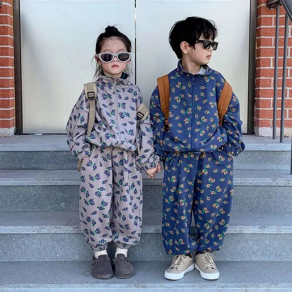 Kids wearing casual floral printed two-piece spring autumn sets holding hands outdoors
